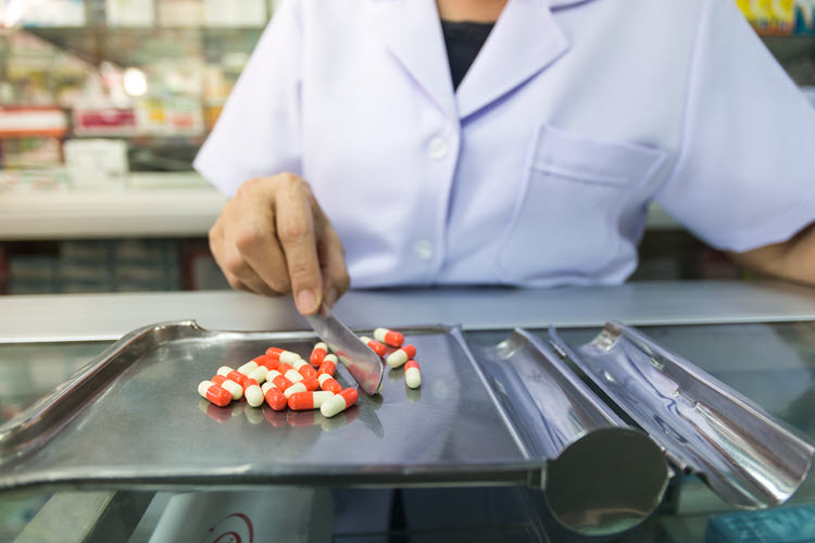Pharmacist sorting medicine on a pill sorting tray